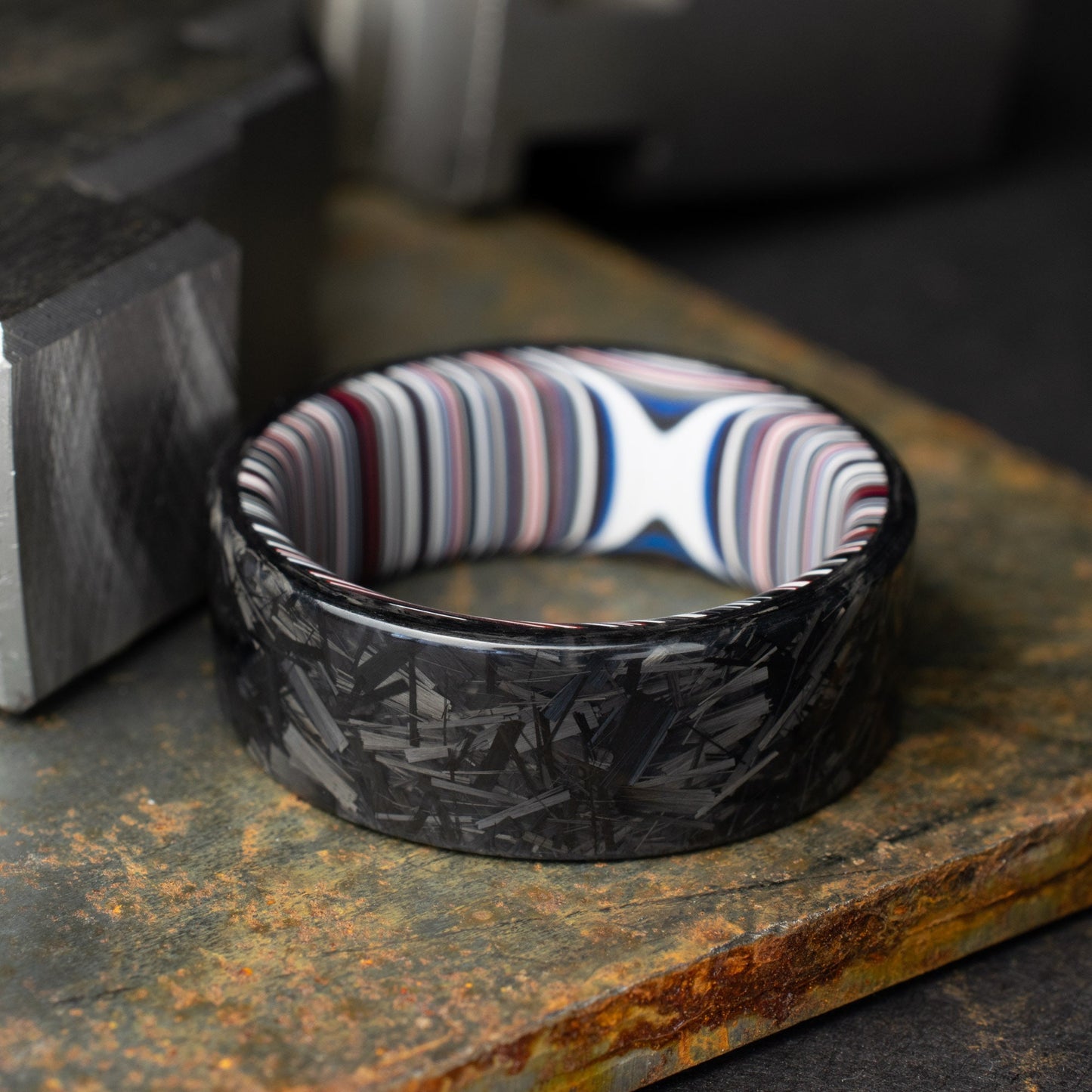 Chopped Carbon Fiber Ring Lined With Crosscut Fordite. Polished Carbon Fiber