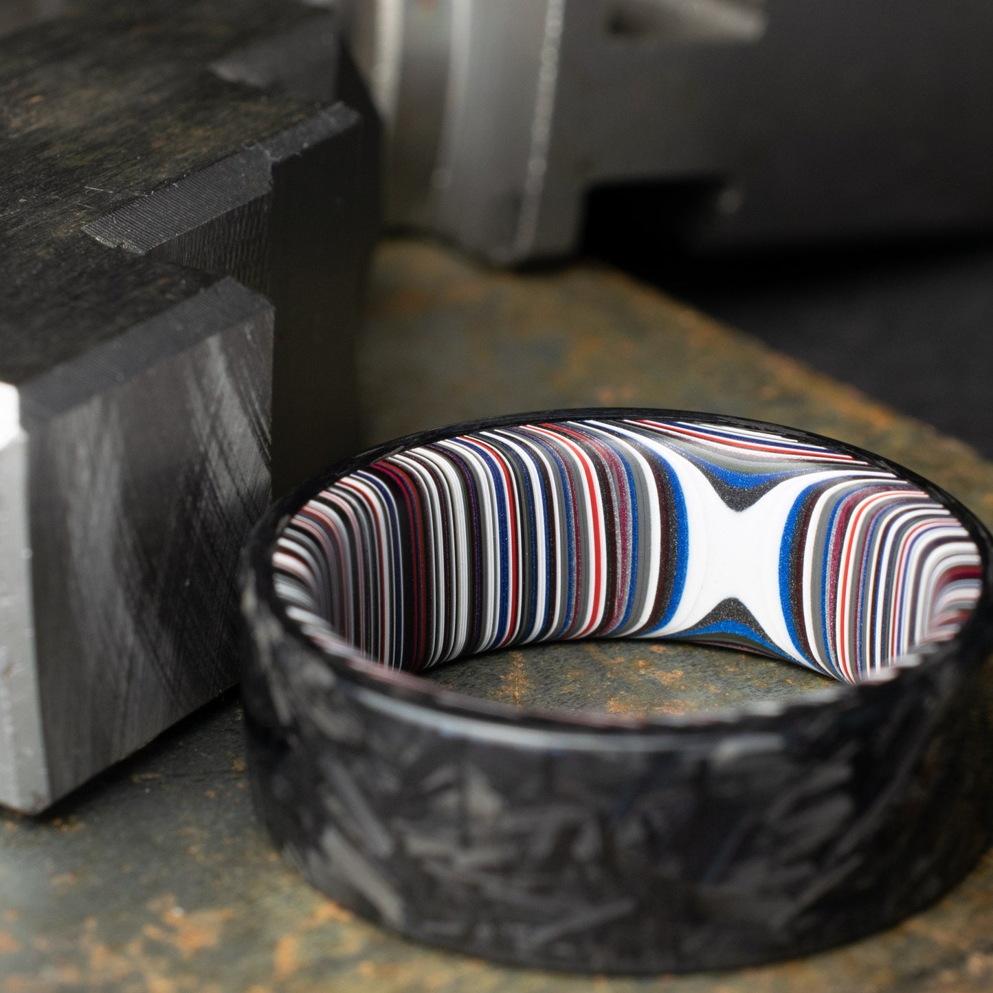 Chopped Carbon Fiber Ring Lined With Crosscut Fordite. Polished Carbon Fiber
